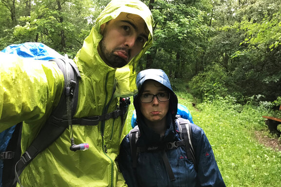 Two wet hikers wearing rain gear on the soonwald trail