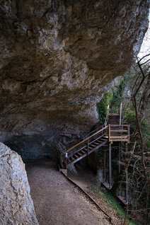Hölzerne Treppe führt in Höhleneingang
